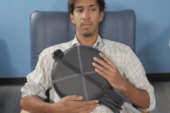 Man presses PEMF Paddles to his chest