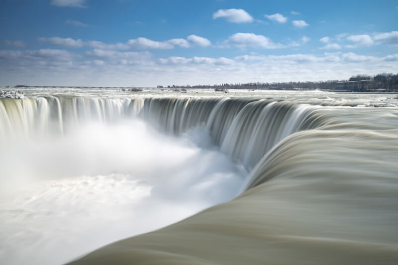 Scenic waterfall flowing gracefully into crystal clear pool below.